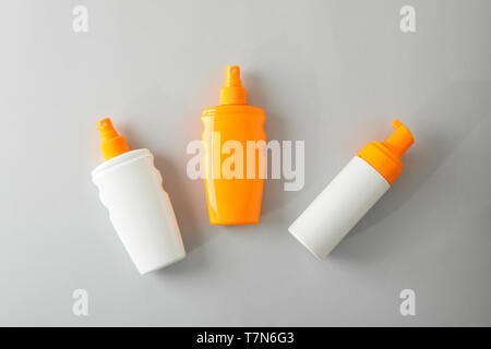 Flat lay composition with sunscreen sprays on grey background. Space for text, top view Stock Photo