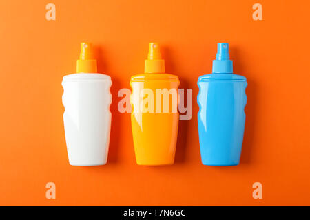 Flat lay composition with sunscreen sprays on color background. Space for text Stock Photo