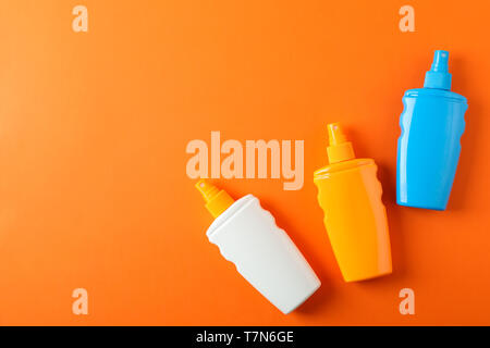 Flat lay composition with sunscreen sprays on color background. Space for text Stock Photo