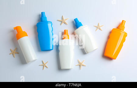 Flat lay composition with sunscreen sprays and starfishes on color background, space for text. Summer vacation backdrop Stock Photo