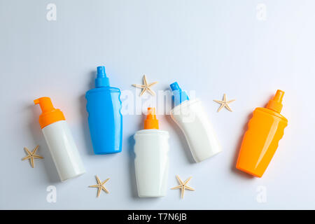 Flat lay composition with sunscreen sprays and starfishes on color background, space for text. Summer vacation backdrop Stock Photo