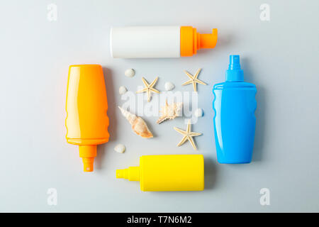 Flat lay composition with sunscreen sprays and starfishes on color background, space for text. Summer vacation backdrop Stock Photo