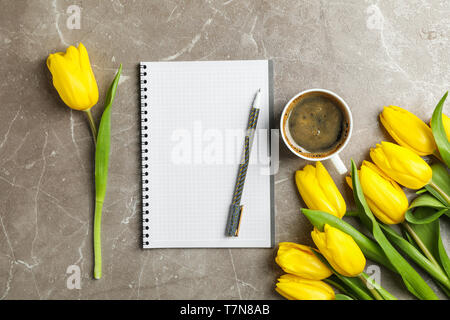 Beautiful tulips, copybook and cup of coffee on grey background Stock Photo