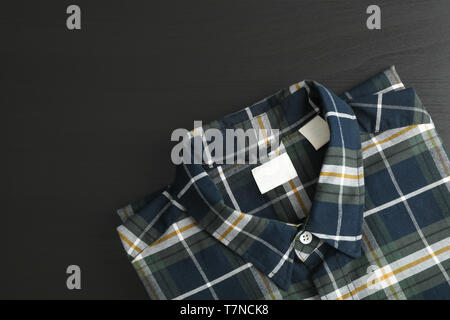 Folded checkered shirt on black table, space for text Stock Photo