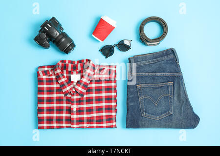 Flat lay composition with shirt, jeans, glasses and camera on color background Stock Photo