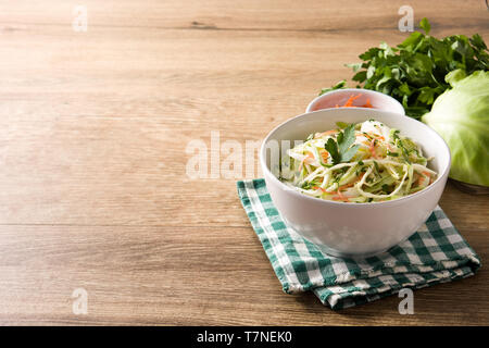 Coleslaw salad in white bowl on wooden table Stock Photo