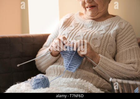 Senior woman knitting warm sock at home Stock Photo