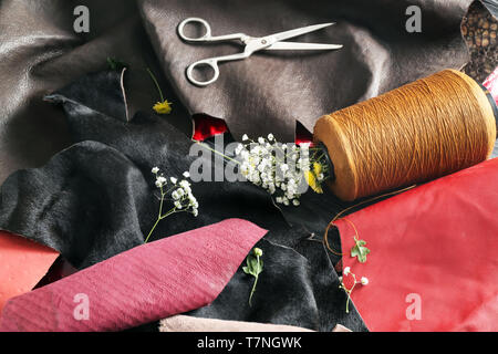 Pieces of colorful leather with thread and scissors on table Stock Photo