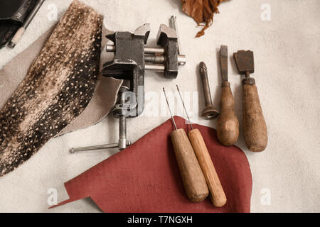 Set of leather working tools on table in workshop Stock Photo