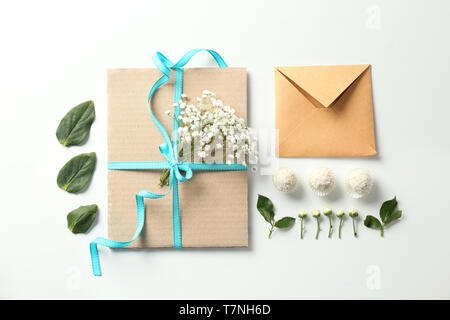Flat lay composition with flowers and envelopes on white background Stock Photo