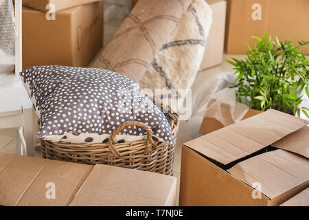 Carton boxes and interior items in room. Moving house concept Stock Photo
