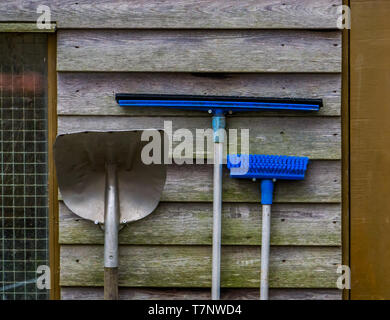 Stable cleaning equipment hanging on a wooden wall Stock Photo