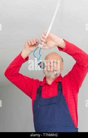 Close up picture of a senior electrician working in a new apartment - electric installation concept Stock Photo