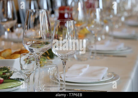 Banquet and catering, table set in the restaurant for celebration. Empty glasses, snacks and plates with napkins on the desk Stock Photo