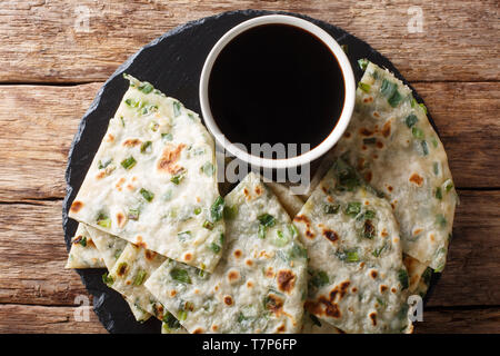 Chinese Scallions pancake also known as green onion pancake or congyoubing  close-up on a board on a table. horizontal top view from above Stock Photo