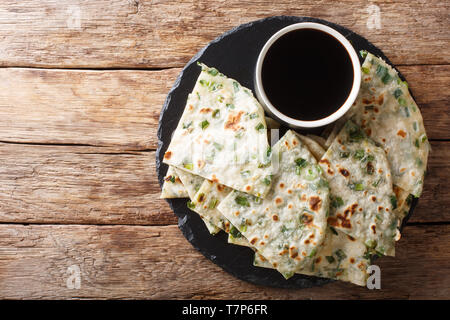 Vegan Scallion Pancakes are a crispy pan-fried Chinese flatbread close-up on a board on the table. horizontal top view from above Stock Photo