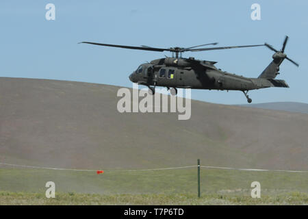 YAKIMA TRAINING CENTER, Wash. – A UH-60 Blackhawk prepares to land at a training area here May 4, 2019, bringing Brig. Gen. Johnny Davis, commander, Joint Modernization Command, and other distinguished visitors to observe Joint Warfighting Assessment 19. JWA 19 is a live, large-scale modernization were participating units can enhance their readiness while integrating and assessing innovative concepts and capabilities in a challenging operational environment. (U.S. Army photo by Pfc. Valentina Y. Montano, 302nd Mobile Public Affairs Detachment) Stock Photo