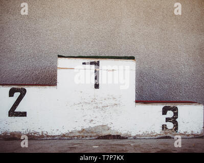 Old-fashioned and damaged podium along a wall in a winter sports resort. France Stock Photo