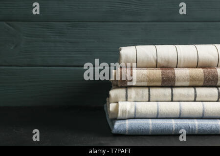 Stack of fabric napkins on black table, space for text Stock Photo