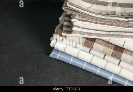 Stack of fabric napkins on black table, space for text Stock Photo