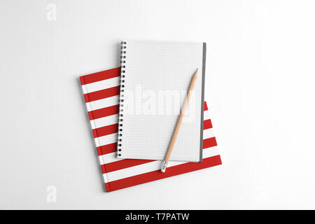 Copybooks and pencil on white background, top view Stock Photo