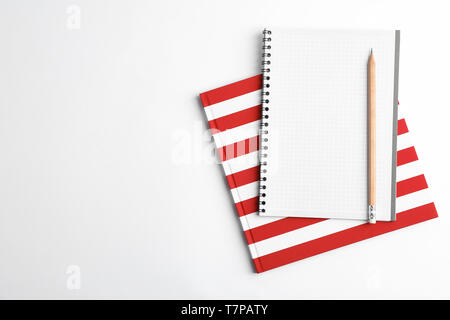 Copybooks and pencil on white background, top view Stock Photo