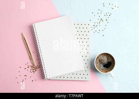 Cup of coffee with copybooks, glitter stars and pen on color background, space for text Stock Photo