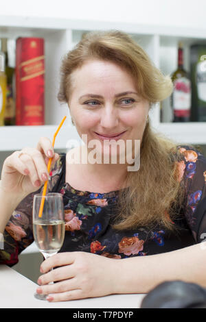 Woman drinking alcoholic cocktail from a straw Stock Photo