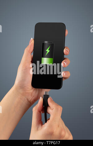 Elegant hand charging cellphone with low battery  Stock Photo