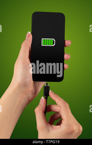 Elegant hand charging cellphone with low battery  Stock Photo