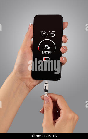 Elegant hand charging cellphone with low battery  Stock Photo