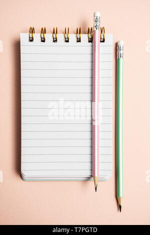 Top view of blank notebook with funny fluffy pen on pink pastel background with copy space, vertical composition Stock Photo