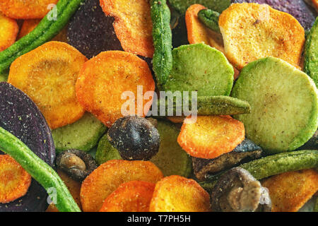 Background of dried vegetables chips from carrot, beet, parsnip, green bean, mushrooms and other vegetables . Healthy snack, organic diet and vegan fo Stock Photo