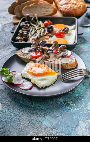 Tasty breakfast. Eggs, sandwich, cheese, vegetables, mushrooms and herbs. Stock Photo