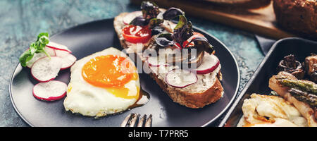 Food banner Delicious homemade breakfast. Fried Eggs, sandwich, cheese, vegetables, mushrooms, bread and herbs. Stock Photo
