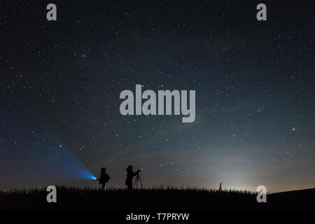 Silhouette photographers with a sky full of stars background at night Stock Photo