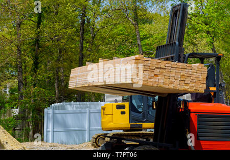 Fork lifter carry construction material beam framework at the building site Stock Photo