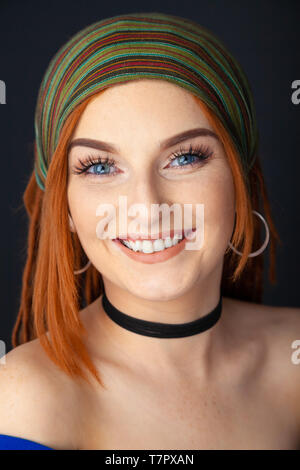 Portrait of a beautiful red headed woman with dreadlocks and wearing a head scarf. Stock Photo