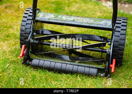 A push lawn mower photographed in a domestic garden on grass. Stock Photo
