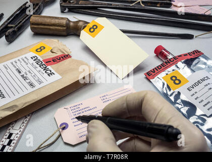 Police expert writes about label evidence number, Various laboratory tests forensic equipment, conceptual image Stock Photo