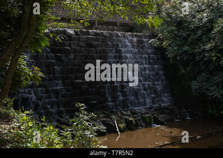 Harewood House, Harewood, Yorkshire, UK, April, 23, 2019: Water trickles down the ornamental wall in the Himalayan Garden at Harewood House, Leeds, Yorkshire, slow shutter speed Stock Photo