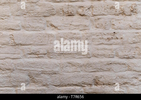 A close up of a white washed brick wall highlights the details of the bricks, ideal as a background or wallpaper Stock Photo