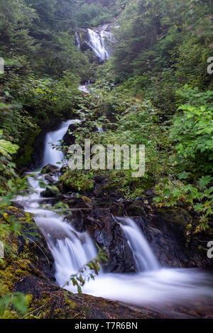 A small multii tiered waterfall just off the side of the road, long exposure shot to smooth out the cascading water Stock Photo