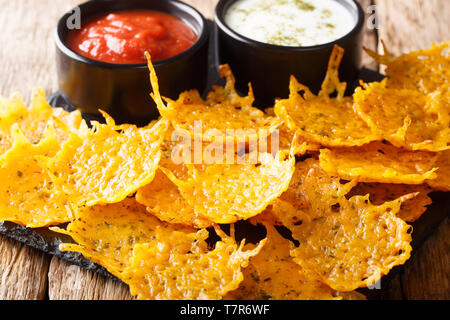 Herb cheddar chips served with sauces close-up on a board on a table. horizontal Stock Photo