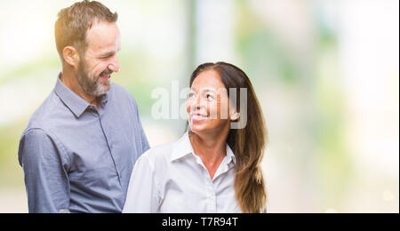 Middle age hispanic business couple over isolated background with serious expression on face. Simple and natural looking at the camera. Stock Photo