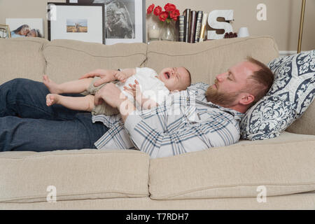 father holds his baby (6 monthes old)  in his home in northern Philadelphia Stock Photo