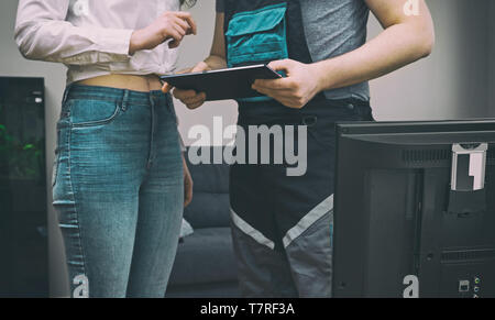 Woman enters into a contract to connect television at home. Stock Photo