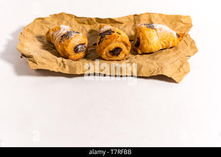 Croissants filled with chocolate on a paper. Isolated with white background Stock Photo