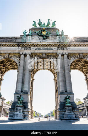 Low angle view of the arcade du Cinquantenaire, the triumphal arch in the Cinquantenaire park in Brussels, Belgium, against the sunlight.