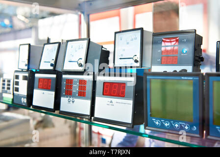 Digital and analog devices for measuring electricity in store Stock Photo